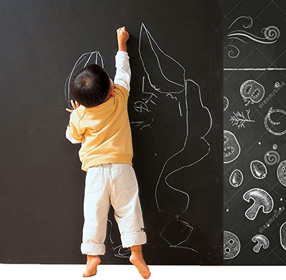 child writing on chalkboard wall